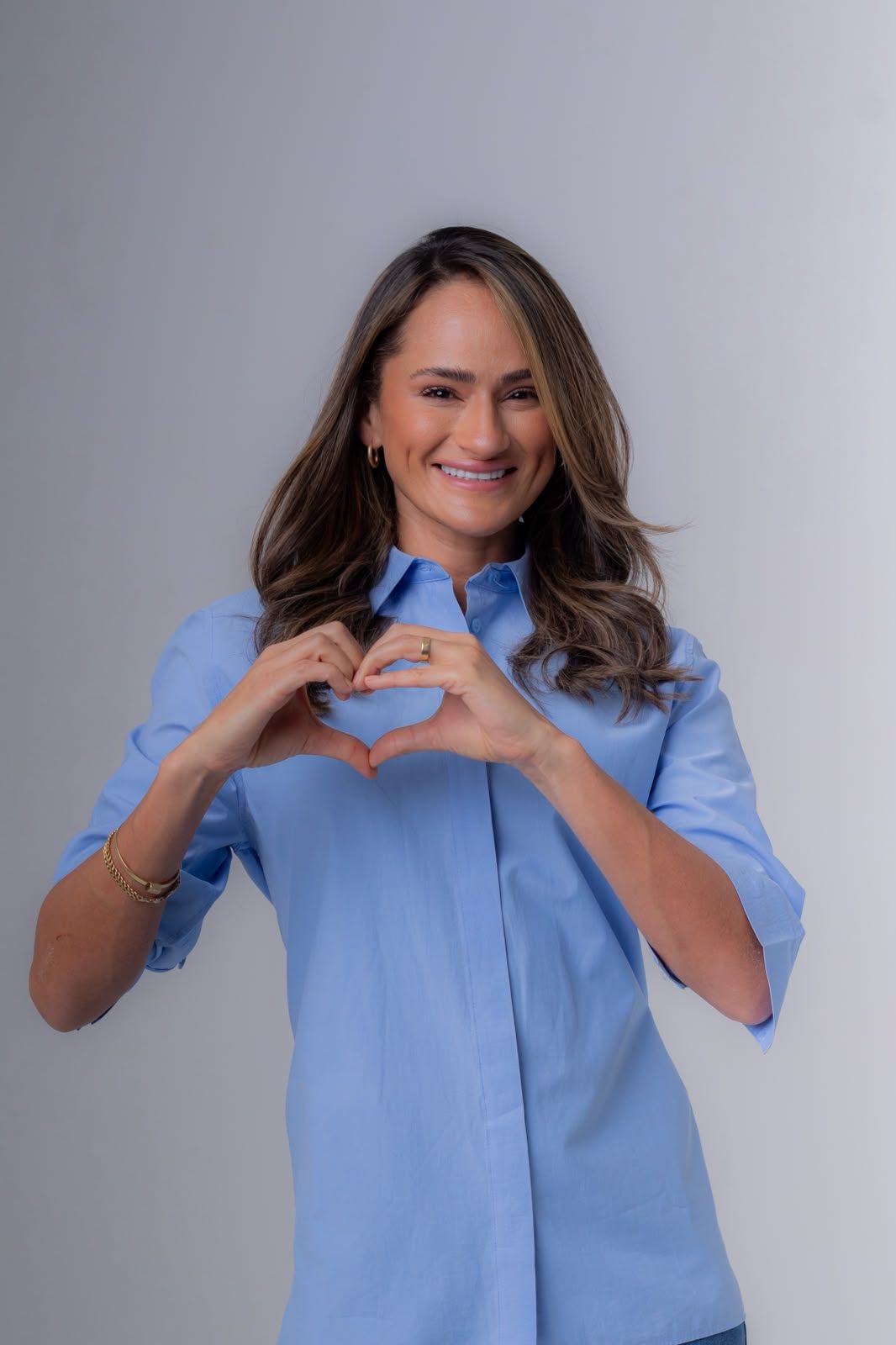 Cecília Rocha sorrindo, com as mãos em formato de coração